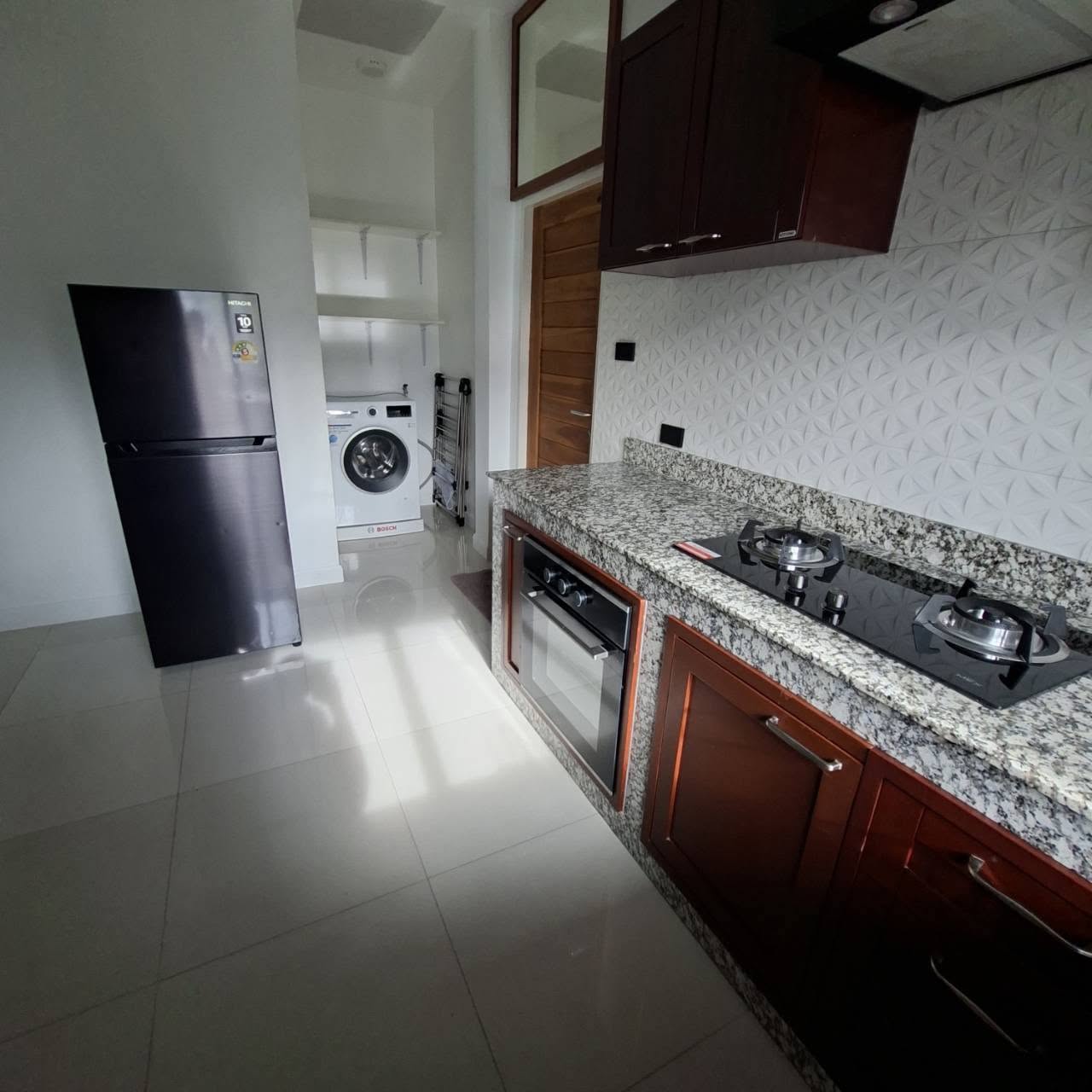 Fully equipped kitchen with granite counters, oven and laundry alcove