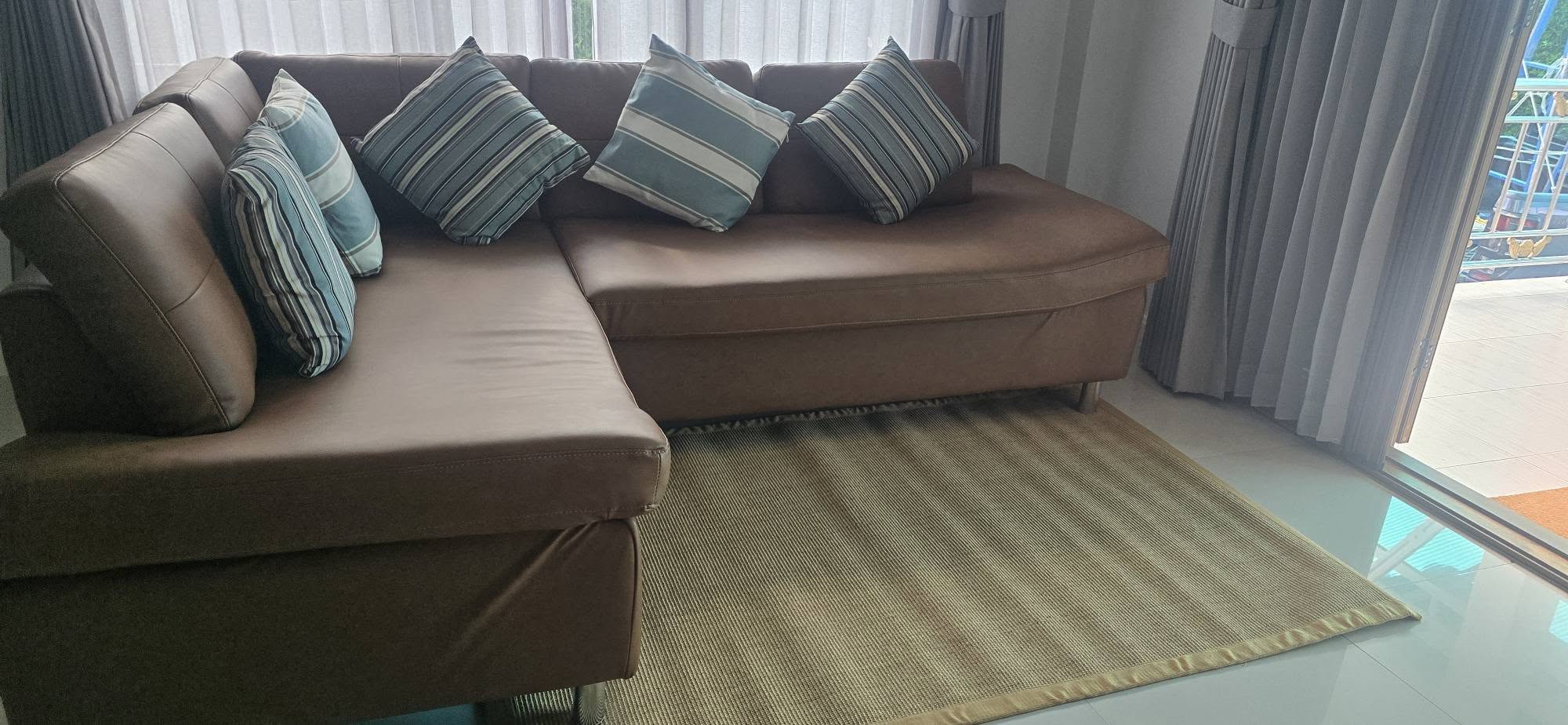 Bright living room with brown L-sofa and balcony light at Yui Villas Samui on Koh Samui